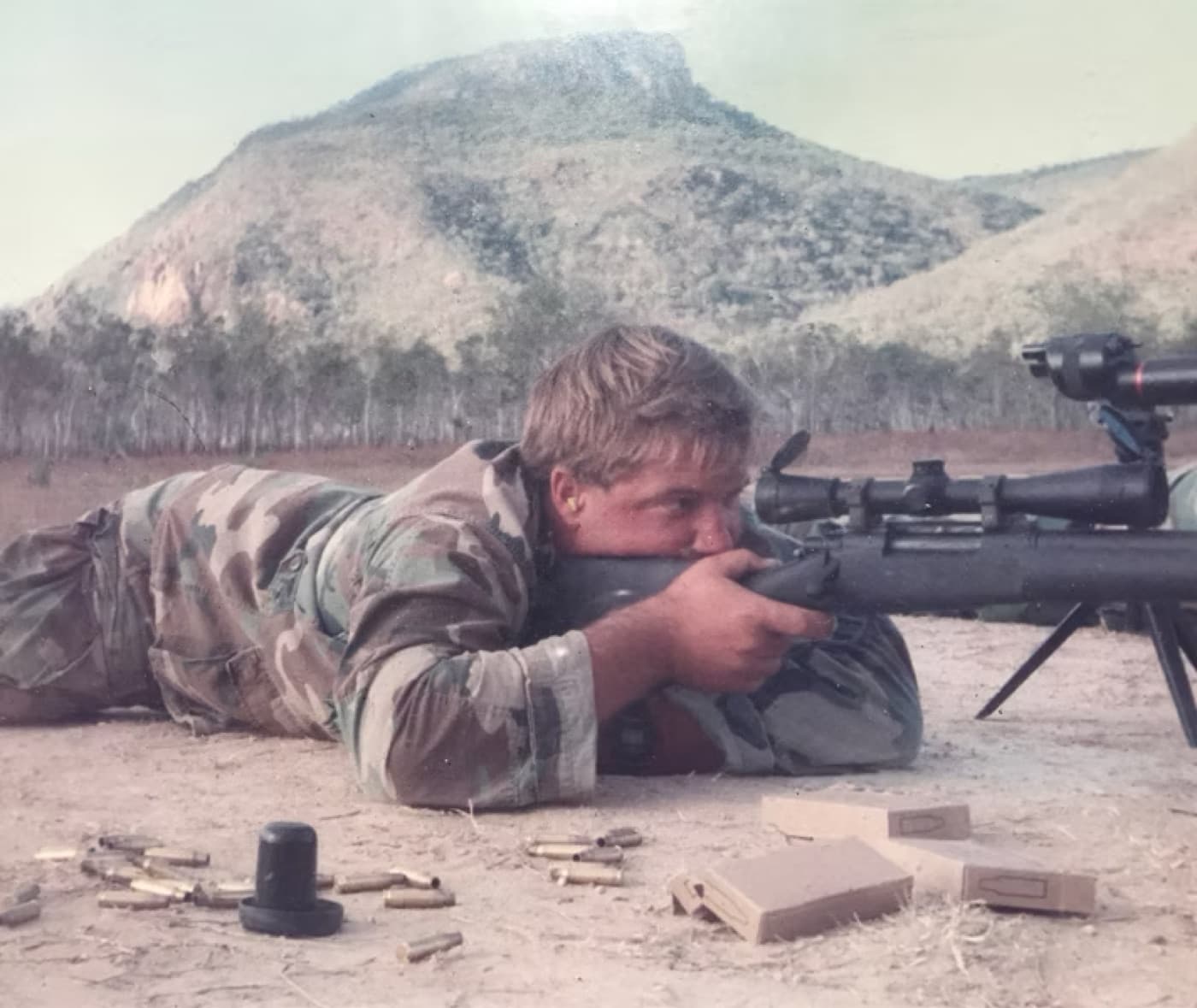 Michael Gilbert in prone position behind a scoped rifle during marksmanship training